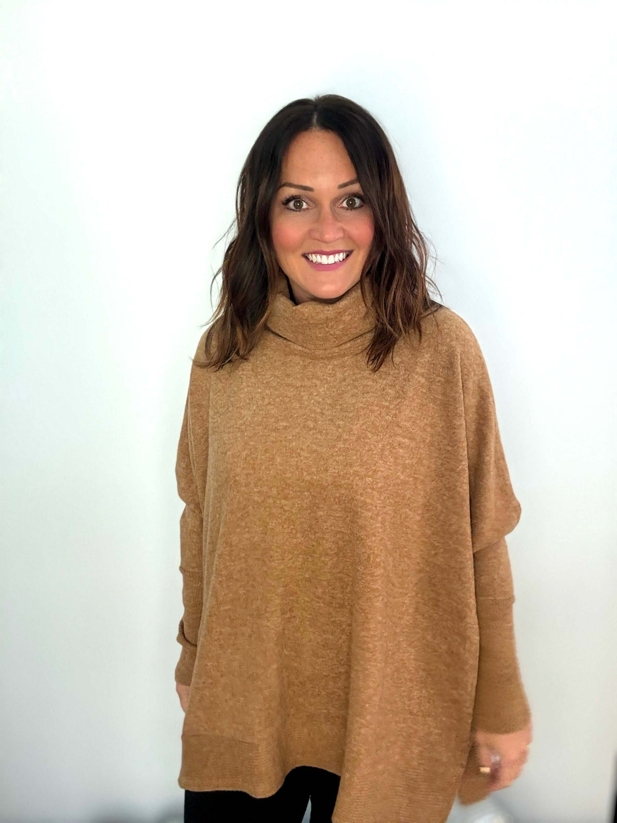 Woman wearing deep camel Wine Tasting Cowl Neck Poncho Sweater with elegant design and cozy feel.