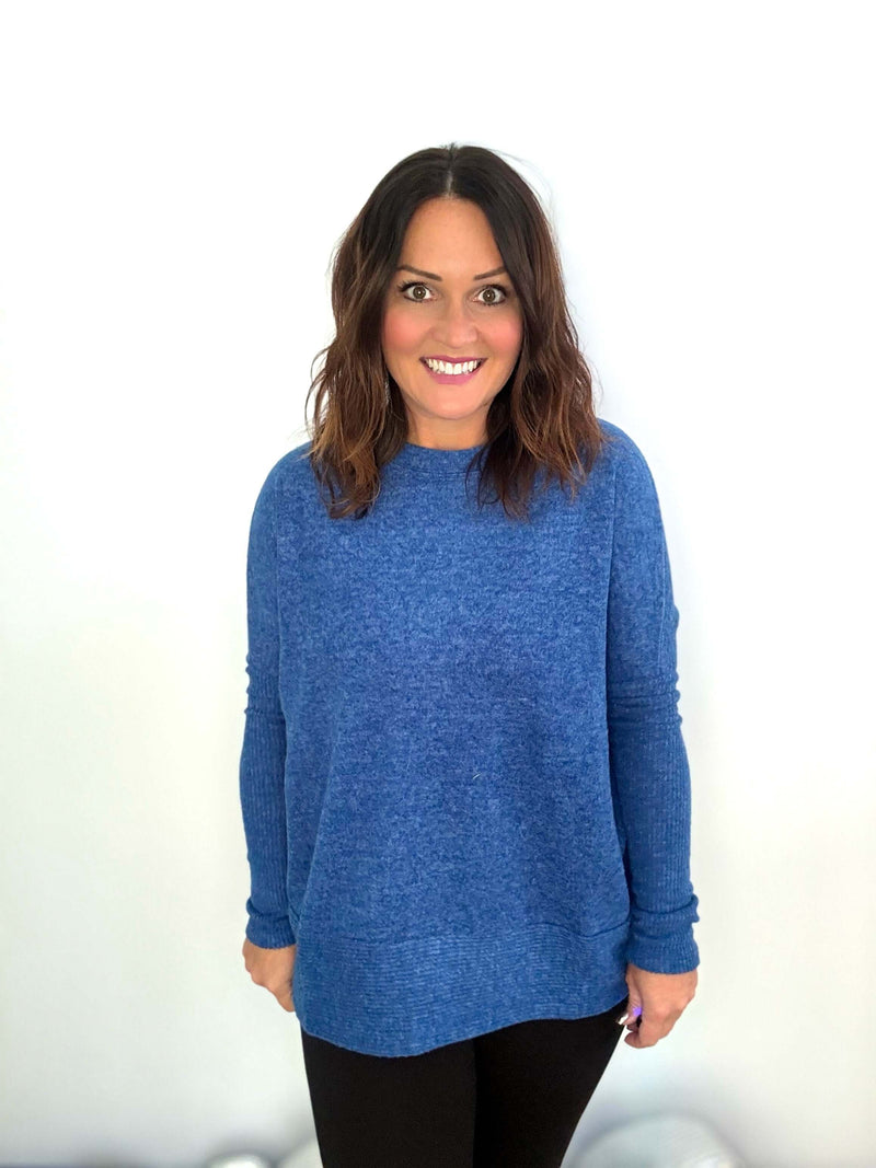 Woman wearing a blue sweater and black pants, featuring the cozy and stylish design for cooler weather.