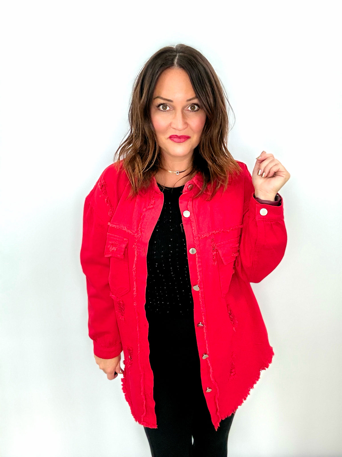 Woman wearing red distressed denim shacket, showcasing bold and edgy fashion style.