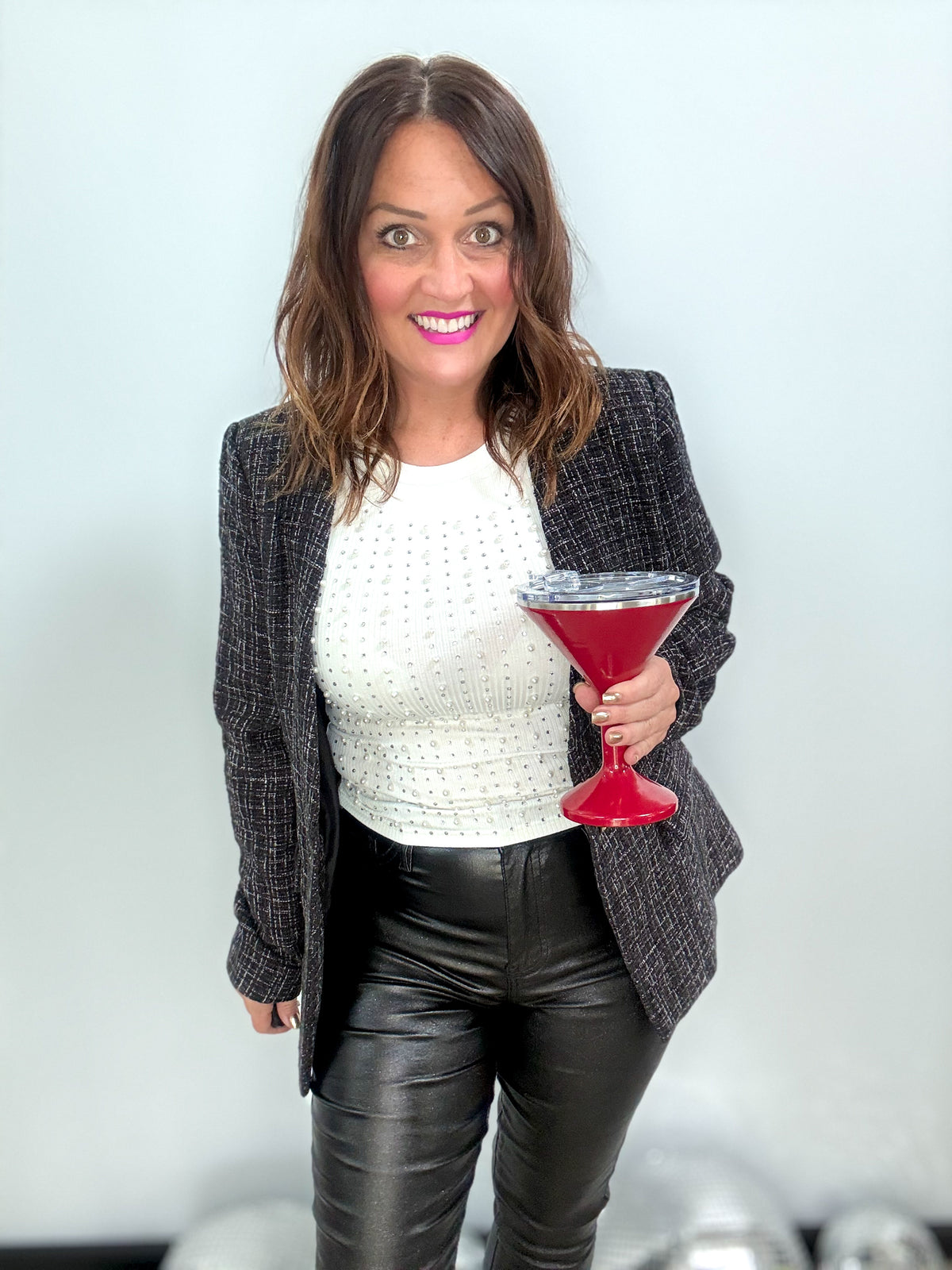 Woman wearing City Lights Blazer holds cocktail, showcasing a chic, confident style suitable for work or holiday events.