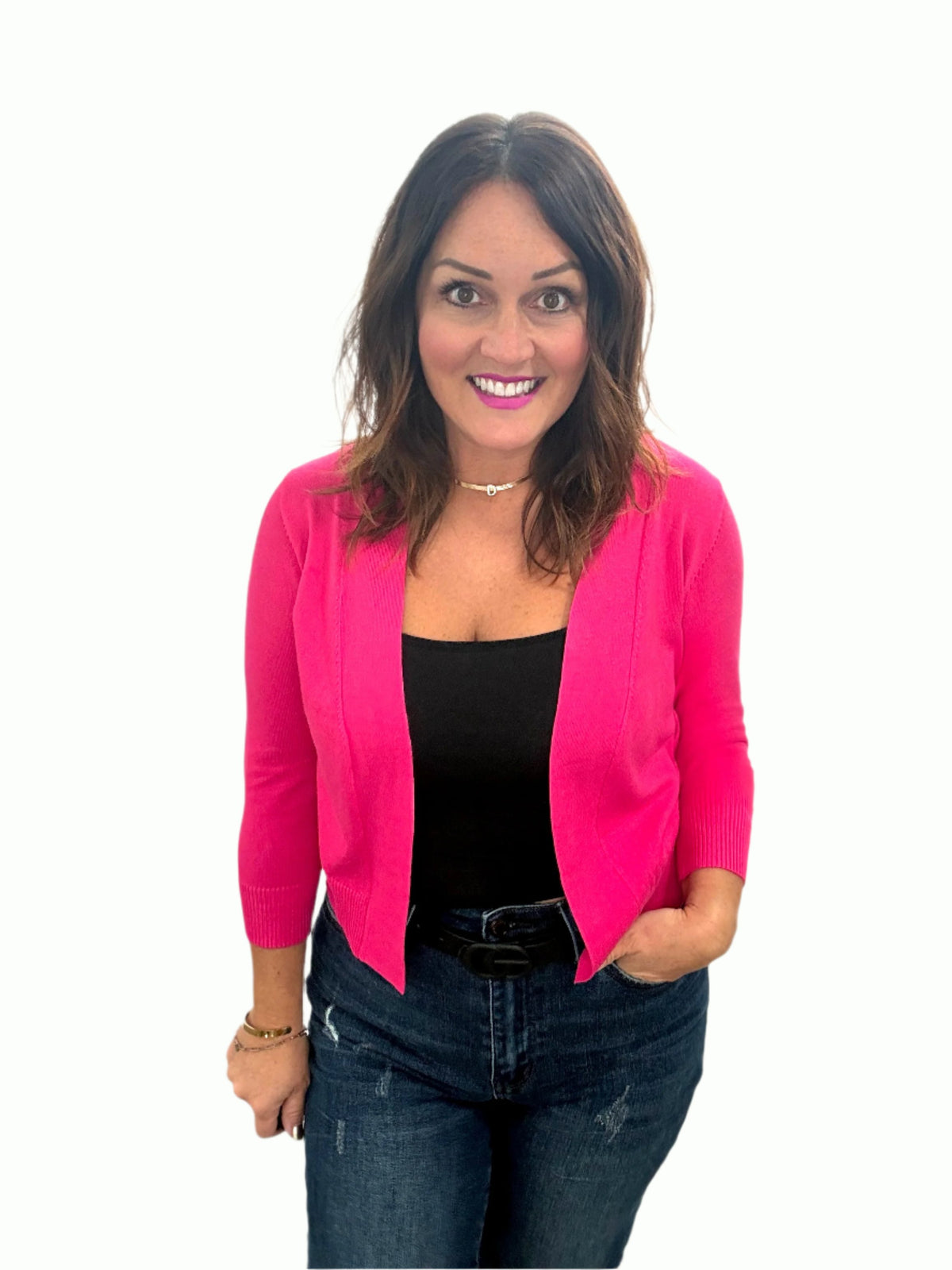 Woman wearing a pink Better in Bolero Knit Cardigan, paired with a black top and jeans, showcasing a stylish women's layering piece.