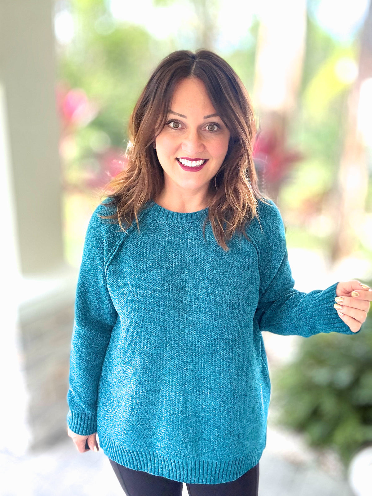 Blue Chenille Dream Sweater with raglan design and round neck, worn by a smiling woman in a cozy outdoor setting.