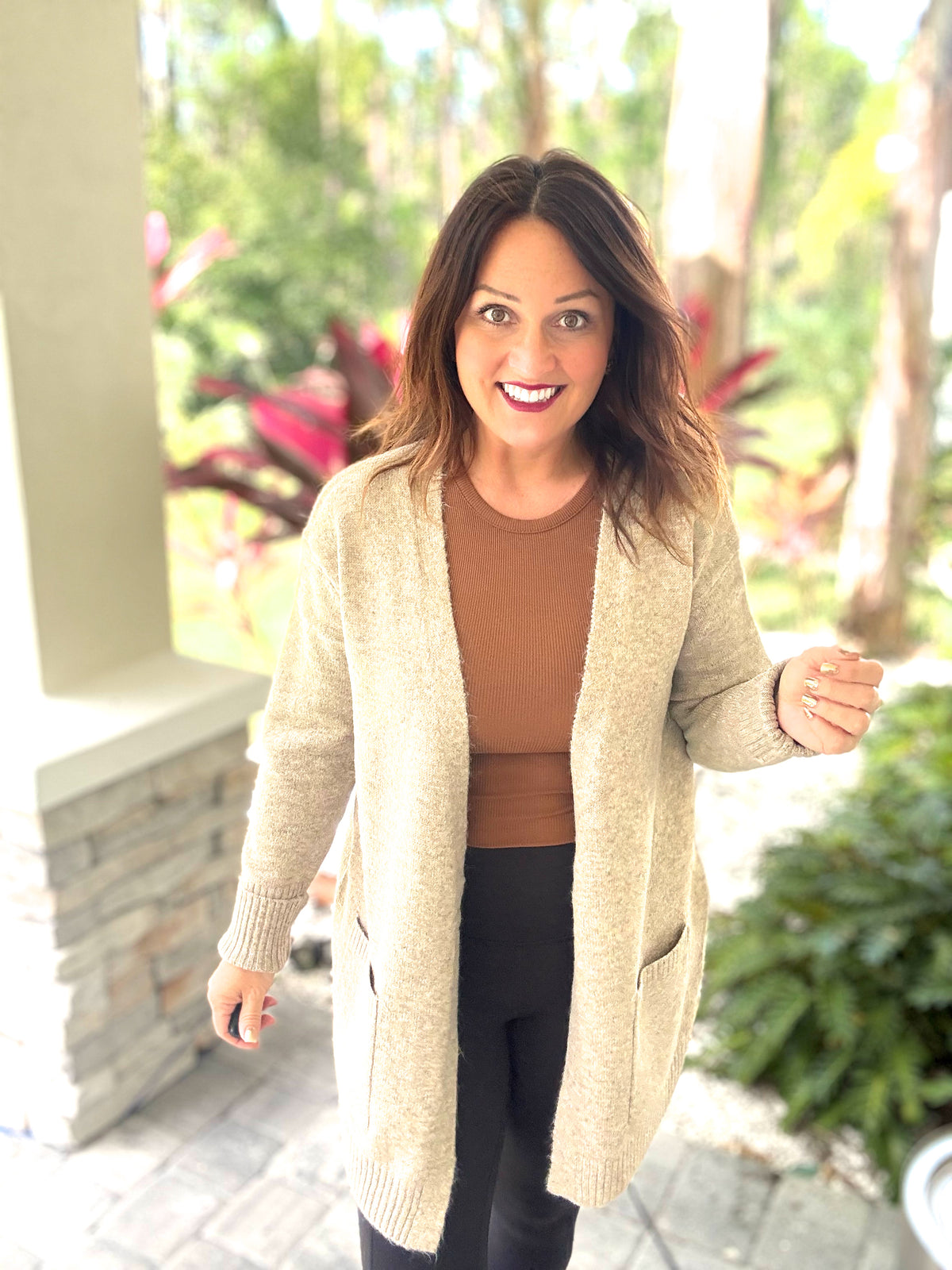 Woman wearing the Autumn Moment Cardigan, showcasing its cozy open design and front pockets, perfect for cool weather style.